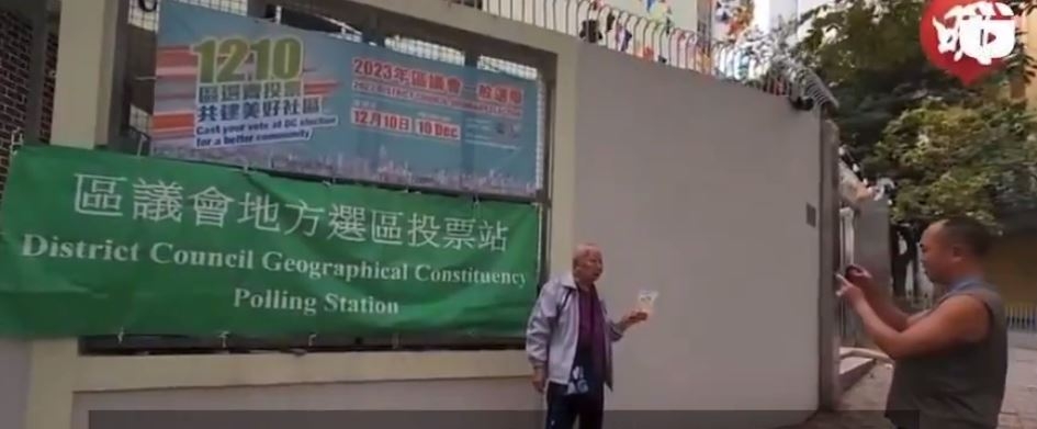 한 홍콩 유권자가 투표소 앞에서 투표 감사 카드를 들고 투표했다는 사실을 인증하는 사진을 찍고 있다. 엑스 캡처