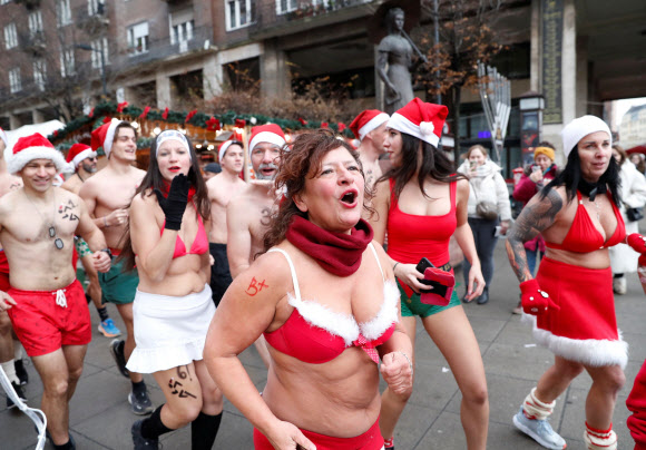 10일(현지시간) 헝가리 부다페스트 시민들이 산타클로스 모자를 쓰고 빨간색 수영복 차림으로 거리를 달리고 있다.  로이터 연합뉴스
