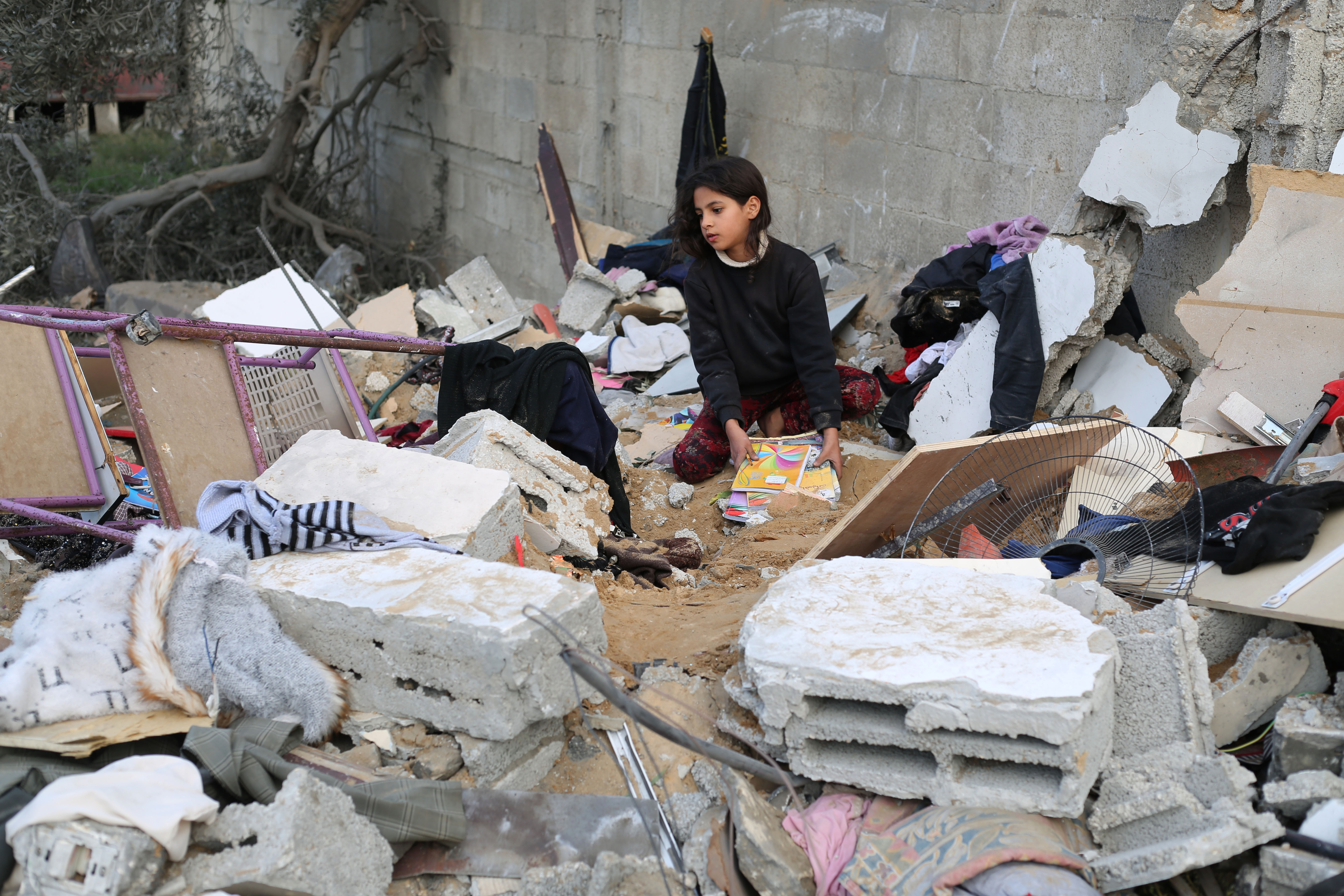 12일(현지시간) 팔레스타인 가자지구 남부 라파 지역에서 한 소녀가 이스라엘의 공습 후 건물 잔해 속을 뒤지고 있다. 2023.12.12 신화 연합뉴스