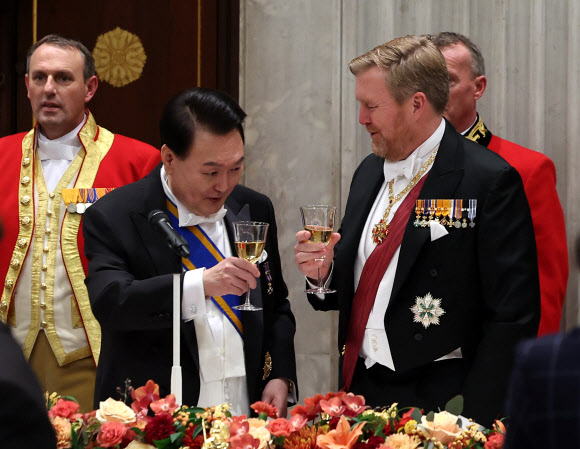 윤석열 대통령과 빌럼-알렉산더르 네덜란드 국왕이 12일(현지시간) 네덜란드 암스테르담 왕궁에서 열린 국빈 만찬에서 건배하고 있다. 2023.12.13 연합뉴스