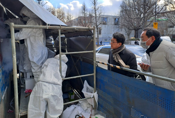 최응천 문화재청장이 16일 오후 스프레이 낙서로 훼손된 서울 종로구 경복궁 영추문 입구를 찾아 긴급 세척 작업 모습을 살펴보고 있다. 2023.12.16 문화재청 제공