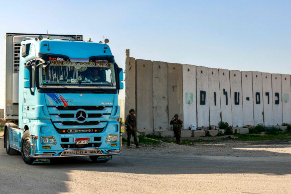 인도적 구호 물품을 실은 트럭 한 대가 19일(현지시간) 케렘 샬롬 국경 검문소를 통과해 팔레스타인 가자지구로 들어가고 있다. 케렘 샬롬 AFP 연합뉴스