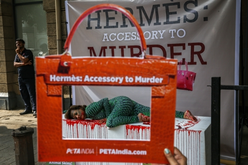 인도의 동물보호 활동가가 지난 1일 악어 가죽 모양의 옷을 입고 가짜 피를 뒤집어쓴 채 에르메스 상점 앞에서 동물 가죽 사용 반대 시위를 벌이고 있다. 뭄바이 EPA  연합뉴스