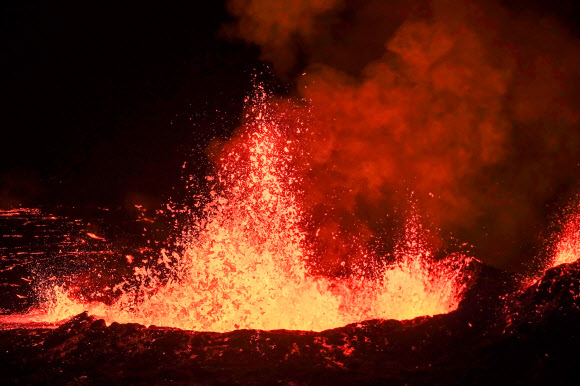 19일(현지시간) 아이슬란드 레이캬네스 반도의 그린다비크에서 화산이 폭발해 시뻘건 용암이 흘러 내리고 있다. AFP 연합뉴스