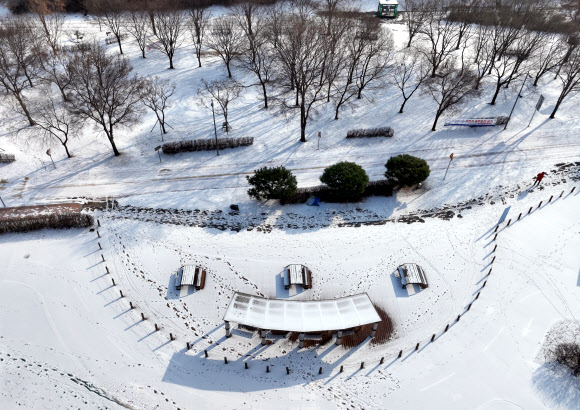 서울에 올겨울 첫 한파경보가 내려진 20일 오후 서울 광진구 광나루한강공원에 눈이 쌓여있다. 2023.12.20  연합뉴스