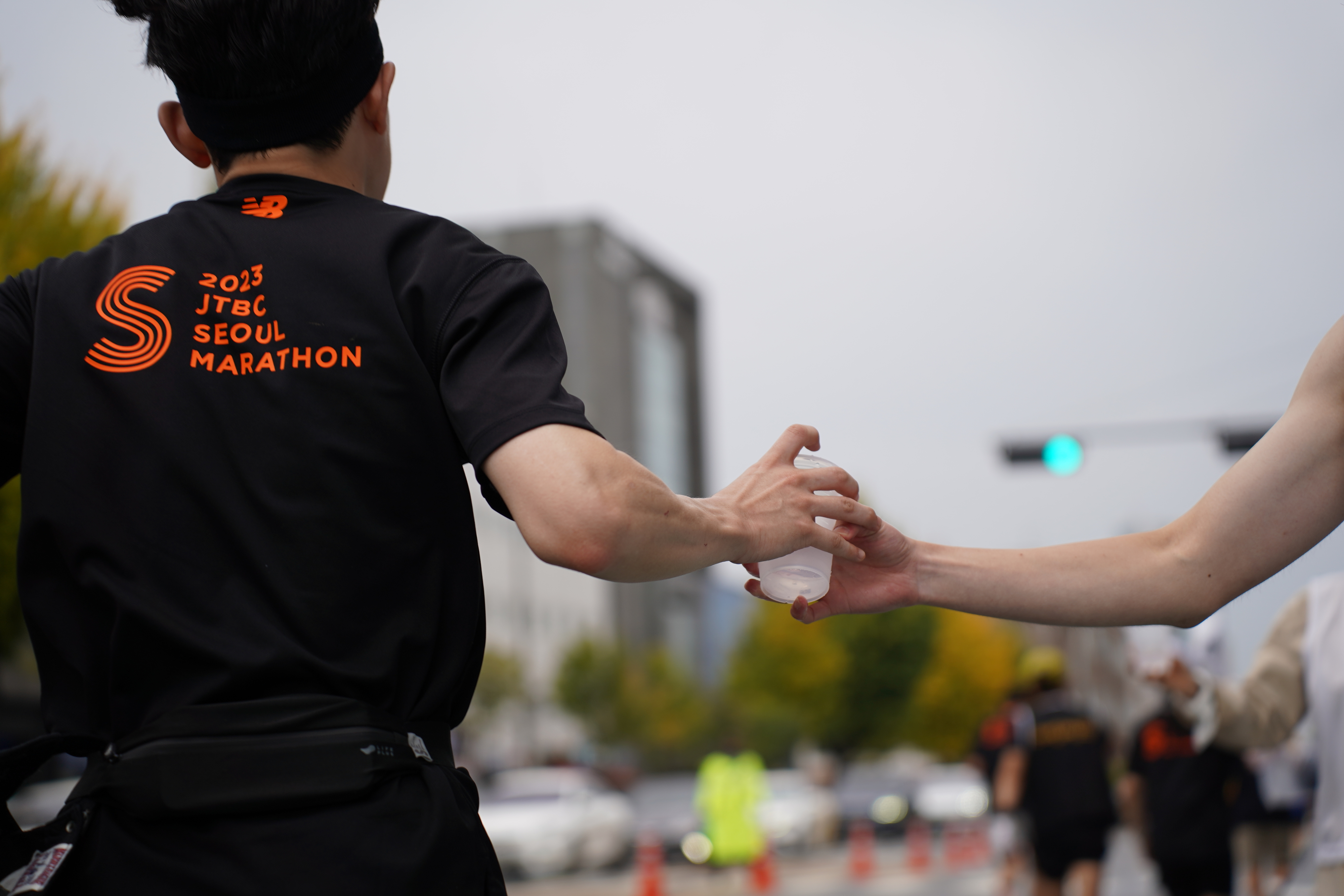 지난달 5일 서울 마포구 상암월드컵공원에서 열린 ‘2023 JTBC 서울마라톤대회’ 참가자가 사단법인 지구닦는사람들(와이퍼스)이 운영한 급수대에서 다회용 컵에 담긴 물을 받아가고 있다. 지구닦는사람들 제공