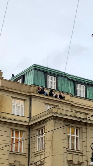 체코 프라하의 카렐대학 예술학부 건물에서 총격 사건이 발생한 직후 사람들이 건물 옥상 아래 발코니 쪽에 앉아 추이를 지켜보고 있다. 소셜미디어 캡처 로이터 연합뉴스