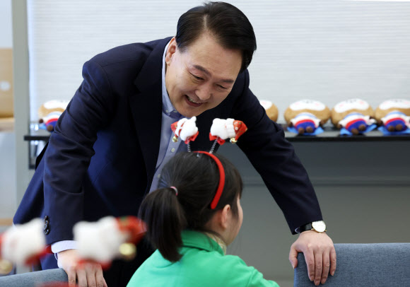 윤석열 대통령이 22일 서울 용산 대통령실 파인그라스에서 열린 ‘히어로즈 패밀리와 함께하는 꿈과 희망의 크리스마스’에 참석한 어린이와 대화하고 있다. 윤 대통령은 이날 행사에 전몰?순직한 군인, 경찰, 소방관 등 제복 입은 영웅들의 자녀와 배우자 등을 초청했다. 2023.12.22   대통령실통신사진기자단