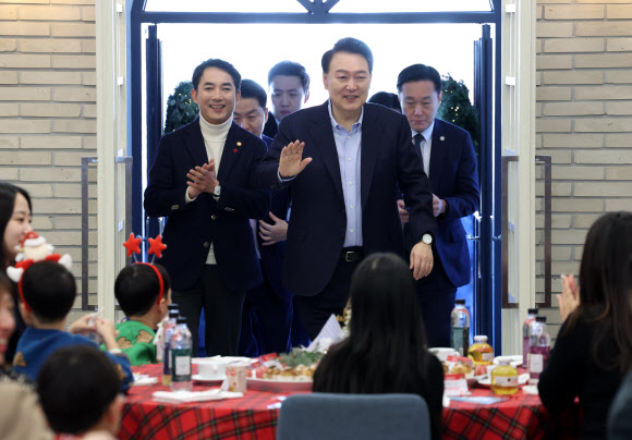 윤석열 대통령이 22일 서울 용산 대통령실 파인그라스에서 열린 ‘히어로즈 패밀리와 함께하는 꿈과 희망의 크리스마스’에 입장하며 손 들어 인사하고 있다. 윤 대통령은 이날 행사에 전몰?순직한 군인, 경찰, 소방관 등 제복 입은 영웅들의 자녀와 배우자 등을 초청했다. 2023.12.22   대통령실통신사진기자단