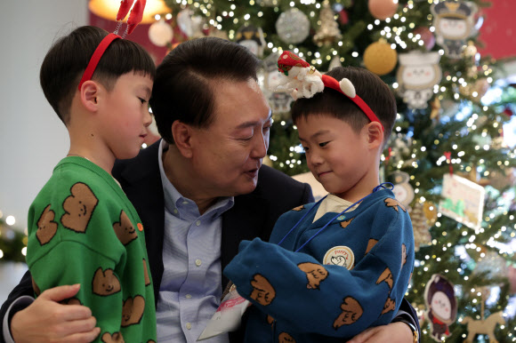 윤석열 대통령이 22일 서울 용산 대통령실 파인그라스에서 열린 ‘히어로즈 패밀리와 함께하는 꿈과 희망의 크리스마스’에서 전몰?순직한 군인, 경찰, 소방관 등 제복 입은 영웅들의 자녀에게 선물을 주고 있다.  2023.12.22   대통령실 제공