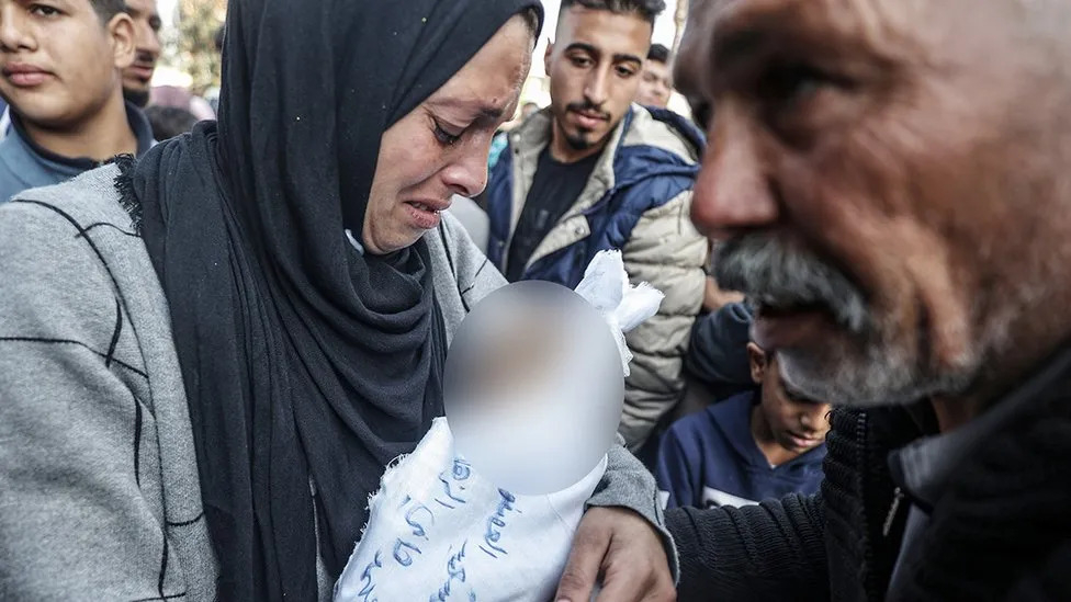 생후 5개월 된 아기 무함마드 하니 알자하르의 주검을 안고 슬퍼하는 엄머와 할아버지. AFP 자료사진