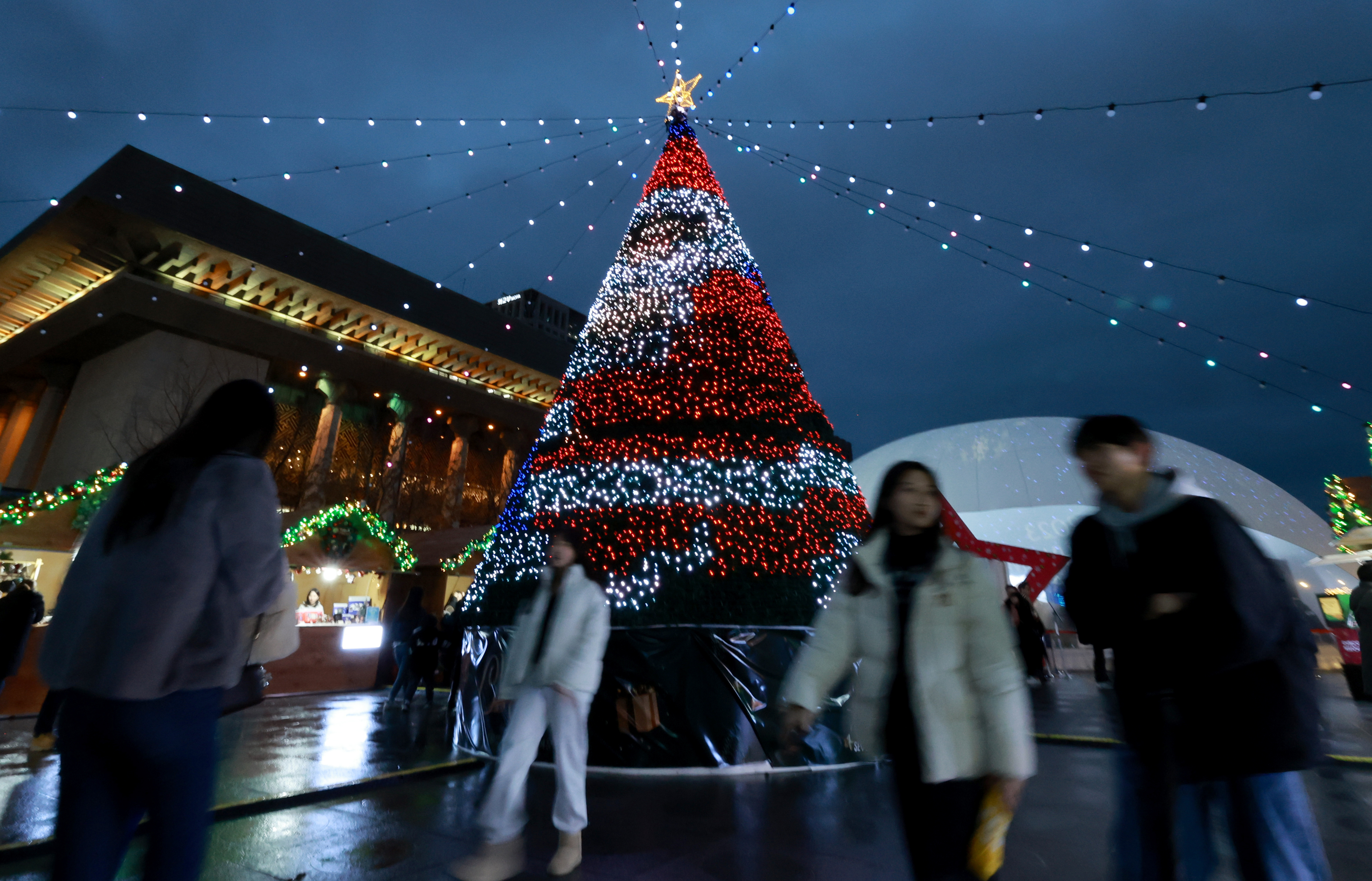 15일 오후 서울 세종대로 광화문광장에서 열린 ‘광화문광장 마켓’ 행사를 찾은 시민들이 LED 전구로 산타를 형상화한 트리 앞을 오가고 있다. 2023.12.15 연합뉴스