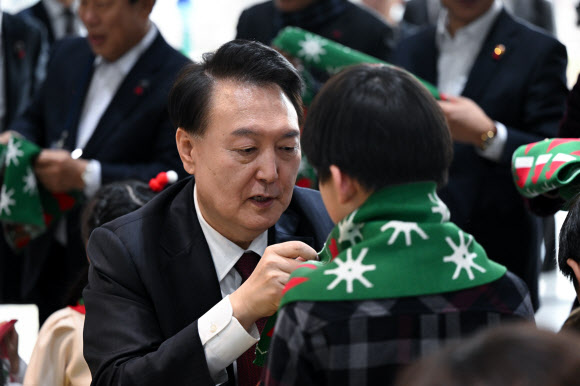 윤석열 대통령이 26일 세종시 국립박물관단지에서 열린 국립어린이박물관 개관식에서 어린이들에게 목도리를 둘러주고 있다. 2023.12.26. 대통령실 제공