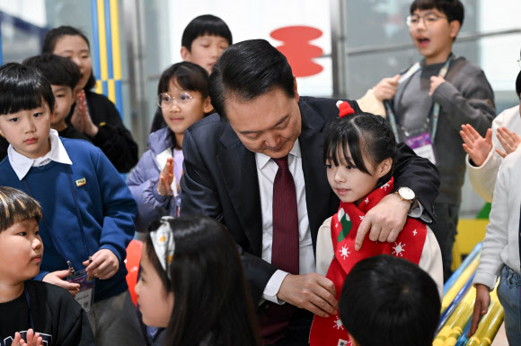 윤석열 대통령이 26일 세종시 국립박물관단지에서 열린 국립어린이박물관 개관식에서 오지율 아역배우 등 어린이들에게 목도리를 둘러주고 있다. 2023.12.26. 대통령실 제공