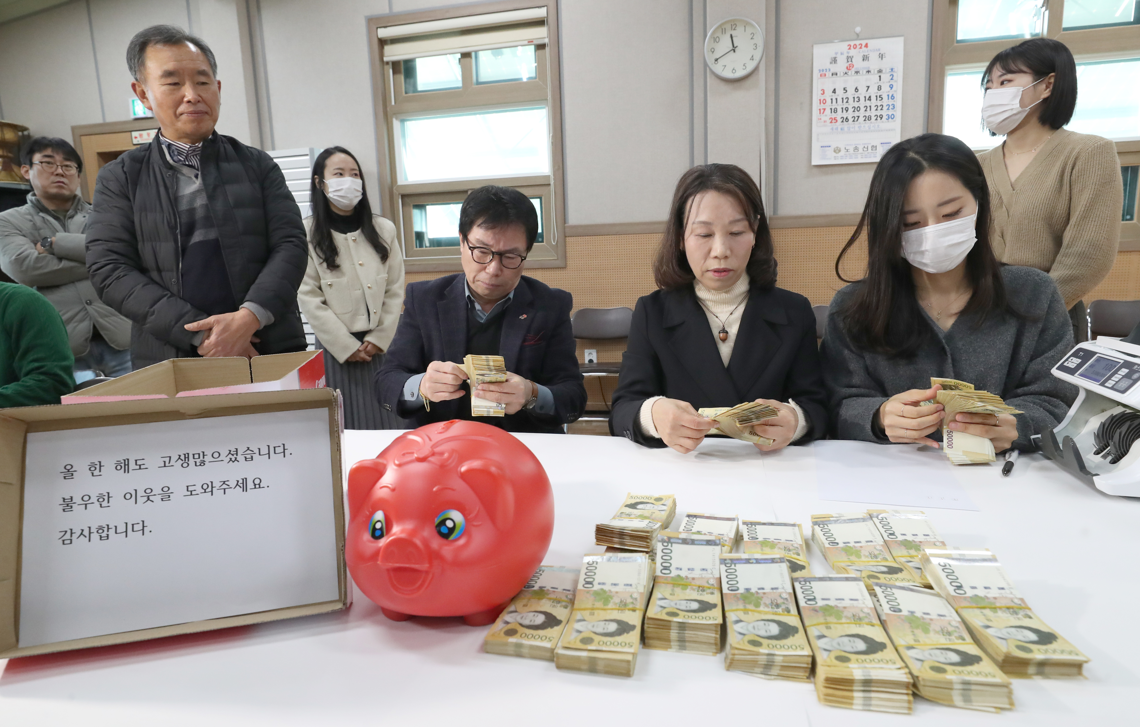 전주시 노송동 주민센터 직원들이 성금을 세고 있는 모습. 전주시 제공