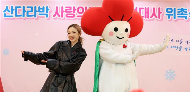 가수 산다라박이 27일 서울 중구 사랑의 열매 대강당에서 열린 홍보대사 위촉식에 참석해 마스코트 열매둥이와 기념촬영을 하고 있다. 2023.12.27 뉴스1