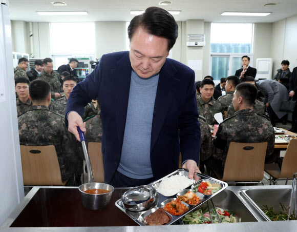 윤석열 대통령이 28일 경기 연천군 군사분계선 전방부대인 육군제5보병사단 5중대 관측소 병영식당에서 장병들과 오찬에 앞서 식판에 음식을 담고 있다. 2023.12.28. 뉴시스