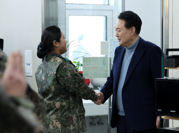 윤석열 대통령이 28일 경기 연천군 군사분계선 전방부대인 육군제5보병사단 5중대 관측소 병영식당에서 장병들과 오찬에 앞서 악수하고 있다. 2023.12.28. 뉴시스