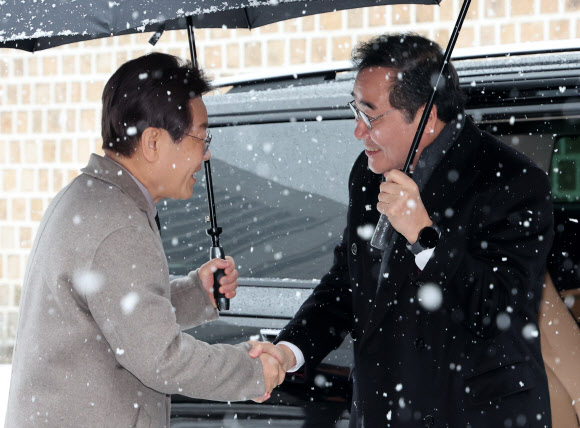 더불어민주당 이재명 대표와 이낙연 전 대표가 30일 오전 서울 중구의 한 식당 앞에서 만나 악수를 하고 있다. 2023.12.30  공동취재