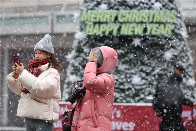 눈이 내리는 30일 오전 서울 중구 명동거리에서 관광객들이 길을 거닐고 있다. 2023.12.30 뉴스1