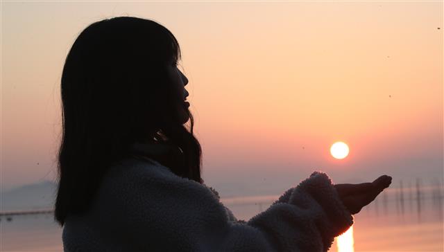 1일 전남 무안군 해제면 도리포에서 한 관광객이 힘차게 떠오르는 갑진년 새해를 바라보며 두손으로 해를 떠받치고 있다.2024.1.1. 뉴스1