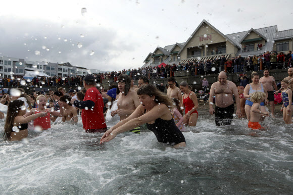 수백명의 사람들이 1일(현지시각) 캐나다 브리티시컬럼비아주 시드니의 글래스비치에서 새해를 맞아 매년 열리는 북극곰 수영대회에 참가해 물 속에서 즐거운 시간을 보내고 있다. AP 연합뉴스