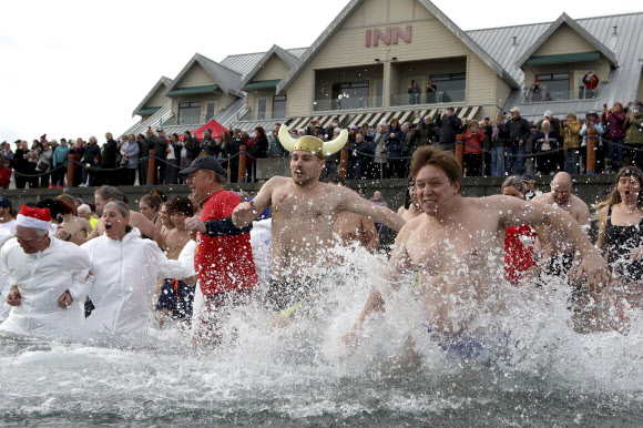 수백명의 사람들이 1일(현지시각) 캐나다 브리티시컬럼비아주 시드니의 글래스비치에서 새해를 맞아 매년 열리는 북극곰 수영대회에 참가해 물 속에서 즐거운 시간을 보내고 있다. AP 연합뉴스