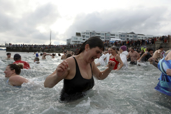 수백명의 사람들이 1일(현지시각) 캐나다 브리티시컬럼비아주 시드니의 글래스비치에서 새해를 맞아 매년 열리는 북극곰 수영대회에 참가해 물 속에서 즐거운 시간을 보내고 있다. AP 뉴시스