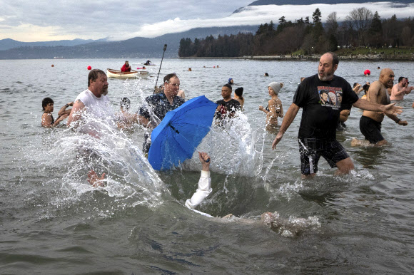 수백명의 사람들이 1일(현지시각) 캐나다 브리티시컬럼비아주 시드니의 글래스비치에서 새해를 맞아 매년 열리는 북극곰 수영대회에 참가해 물 속에서 즐거운 시간을 보내고 있다. AP
