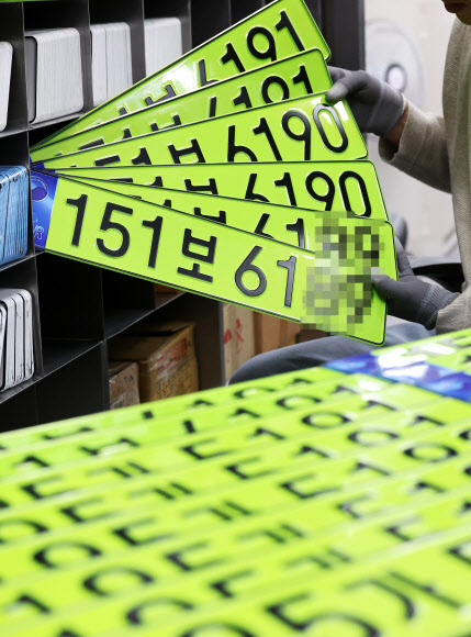 8일 오전 경기도 수원시 권선구 수원도시공사 번호판제작소에서 직원이 고액 법인차량용 연두색 번호판을 정리하고 있다. 올해부터는 8천만원 이상 신규 등록 법인 차량은 연두색 번호판을 부착해야 한다. 2024.1.8  연합뉴스