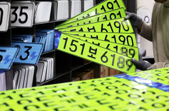 8일 오전 경기도 수원시 권선구 수원도시공사 번호판제작소에서 직원이 고액 법인차량용 연두색 번호판을 정리하고 있다. 올해부터는 8천만원 이상 신규 등록 법인 차량은 연두색 번호판을 부착해야 한다. 2024.1.8  연합뉴스