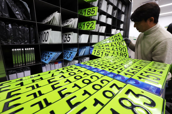 8일 오전 경기도 수원시 권선구 수원도시공사 번호판제작소에서 직원이 고액 법인차량용 연두색 번호판을 정리하고 있다. 올해부터는 8천만원 이상 신규 등록 법인 차량은 연두색 번호판을 부착해야 한다. 2024.1.8  연합뉴스