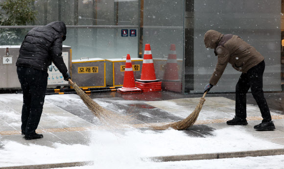 서울을 비롯한 수도권에 대설주의보가 내려진 9일 오전 서울 강남역 인근 건물 관계자가 눈을 치우고 있다. 2024.01.09. 뉴시스