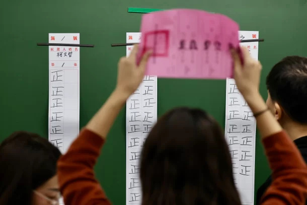 한 선거관리위원이 투표지 한 장 한 장씩, 결과를 말하고 이를 대중에게 보여주고, 한명은 정(正)자로 표를 집계한다. EPA 연합뉴스