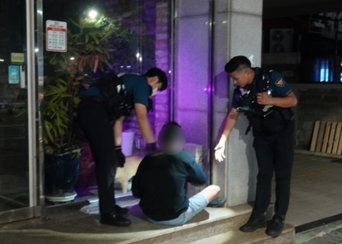 제주 연동지구대 경찰관들이 순찰 중 노상에 주취자가 자고 있는 것을 발견하고 귀가 조처하고 있다. 뉴시스