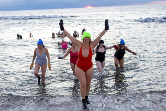 Zoe Weldon gestures while coming back from the water after taking part in a sunrise swim, with a group who call themselves “The Endorphins”, in the chilly waters of Lake Ontario during freezing temperatures in Toronto, Ontario, Canada January 17, 2024. REUTERS 연합뉴스