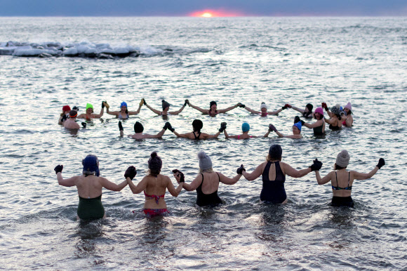 A group, consisting mostly of women, who call themselves “The Endorphins” gather for a sunrise swim in the chilly waters of Lake Ontario during freezing temperatures in Toronto, Ontario, Canada January 17, 2024. REUTERS 연합뉴스