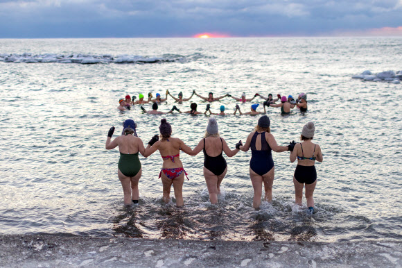 A group, consisting mostly of women, who call themselves “The Endorphins” gather for a sunrise swim in the chilly waters of Lake Ontario during freezing temperatures in Toronto, Ontario, Canada January 17, 2024. REUTERS 연합뉴스