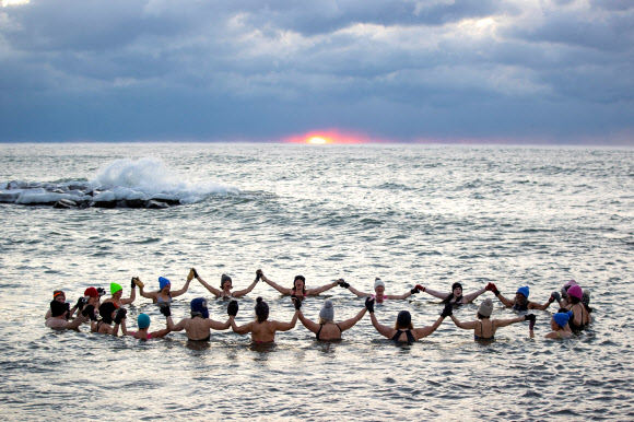 A group consisting mostly of women, who call themselves “The Endorphins”, gather for a sunrise swim in the chilly waters of Lake Ontario during freezing temperatures in Toronto, Ontario, Canada January 17, 2024. REUTERS 연합뉴스
