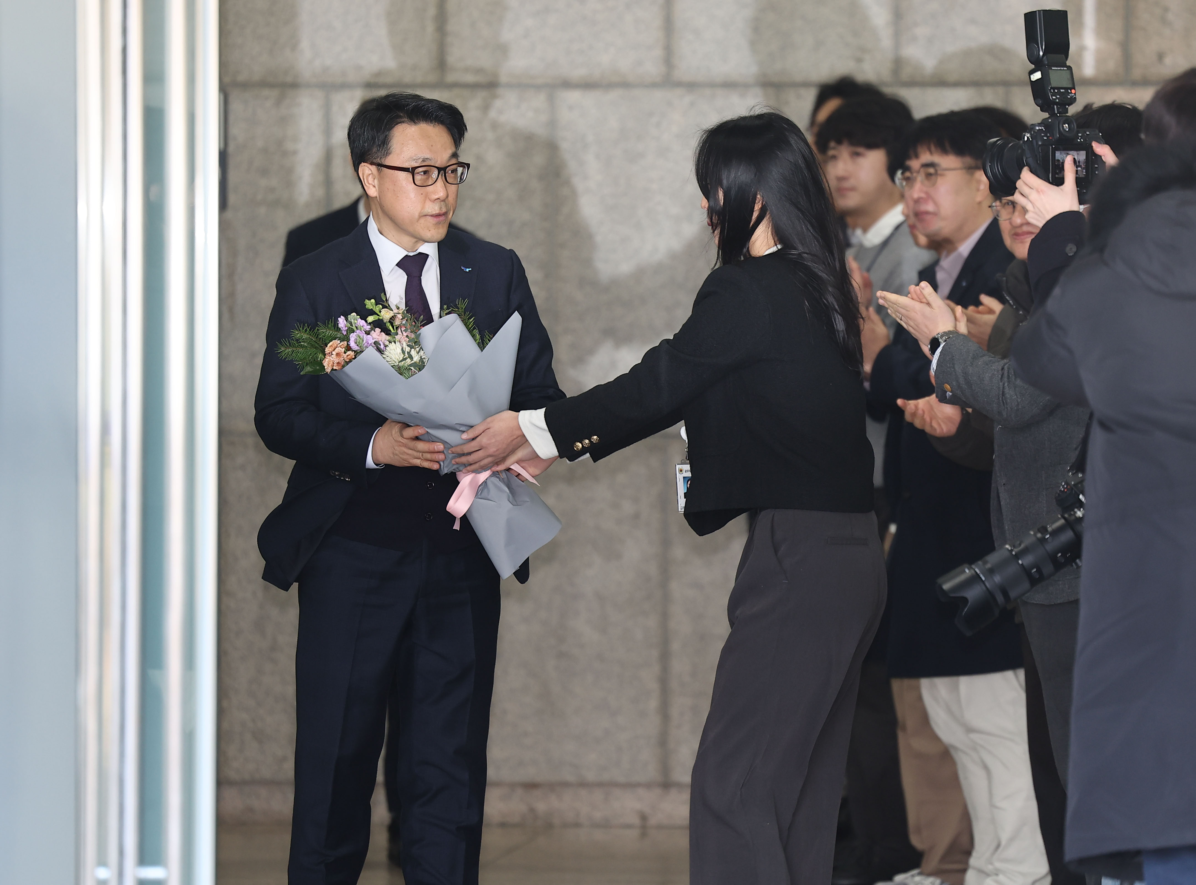 김진욱 고위공직자범죄수사처장이 19일 오전 정부과천청사 공수처에서 열린 이임식을 마친 뒤 건물을 나서며 직원들로부터 꽃다발을 받고 있다. 2024.1.19 연합뉴스