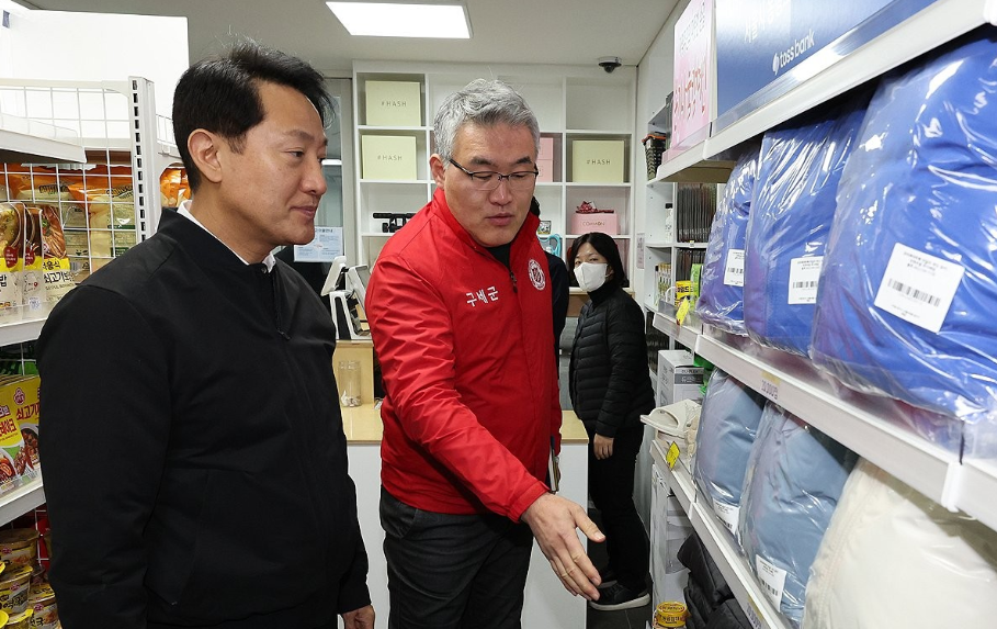오세훈(왼쪽) 서울시장이 지난해 12월 14일 종로구 돈의동 ‘온기창고’ 2호점에서 관계자의 설명을 듣고 있다.   서울시 제공