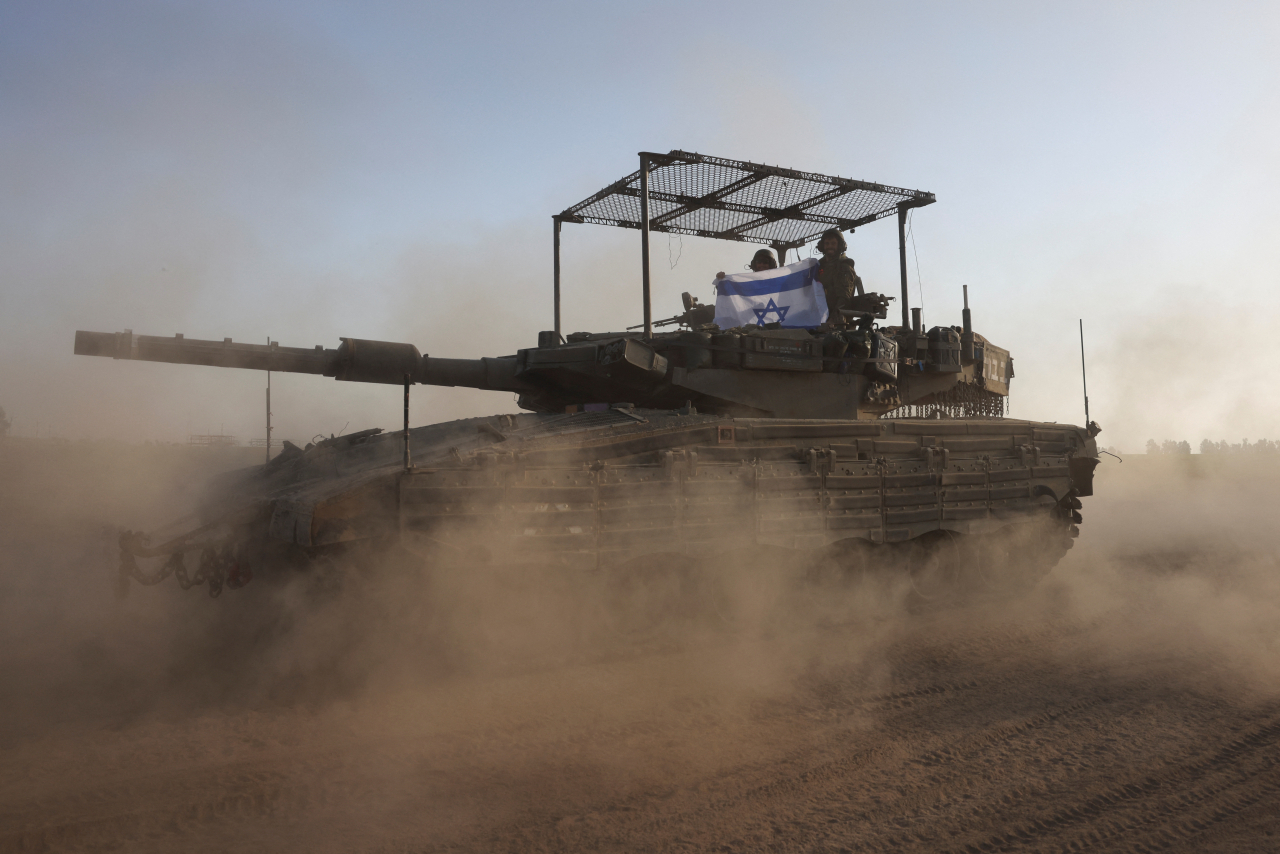 지난해 10월 7일(현지시간) 자국을 기습공경한 팔레스타인 무장정파 하마스 소탕을 위한 가자지구 지상전에 투입된 이스라엘군 병사들과 탱크. 가자 로이터 연합뉴스