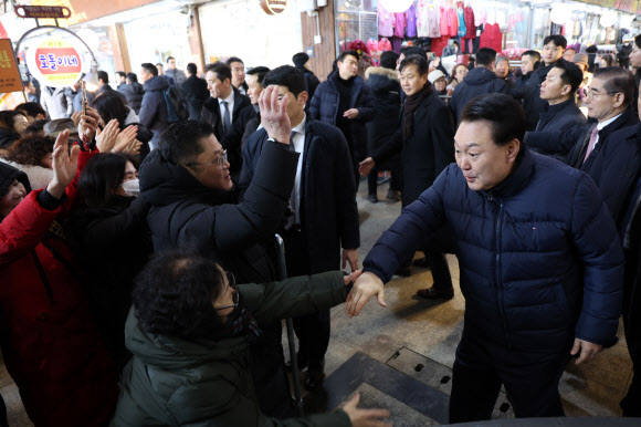 윤석열 대통령이 25일 경기도 의정부시 의정부제일시장을 찾아 상인, 시민들과 악수하며 인사하고 있다. 2024.1.25 연합뉴스