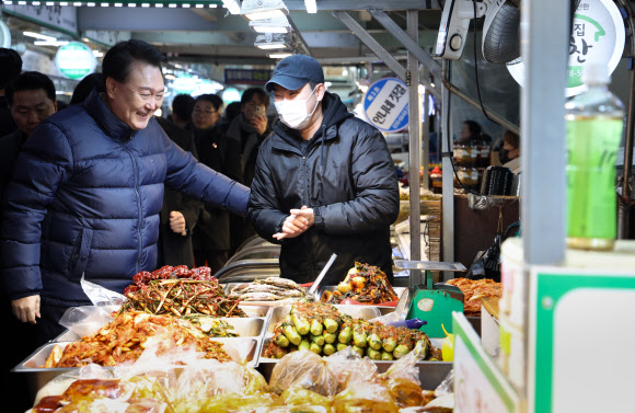윤석열 대통령이 25일 경기도 의정부시 의정부제일시장을 찾아 반찬가게를 운영하는 한 청년사장을 격려하고 있다. 2024.1.25 연합뉴스