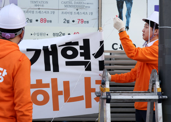개혁신당 이준석 대표 등이 26일 국회의사당 앞 가로수에 정당 정책 홍보 현수막을 걸고 있다. 2024.1.26 연합뉴스