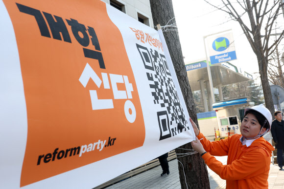개혁신당 이준석 대표 등이 26일 국회의사당 앞 가로수에 정당 정책 홍보 현수막을 걸고 있다. 2024.1.26 연합뉴스