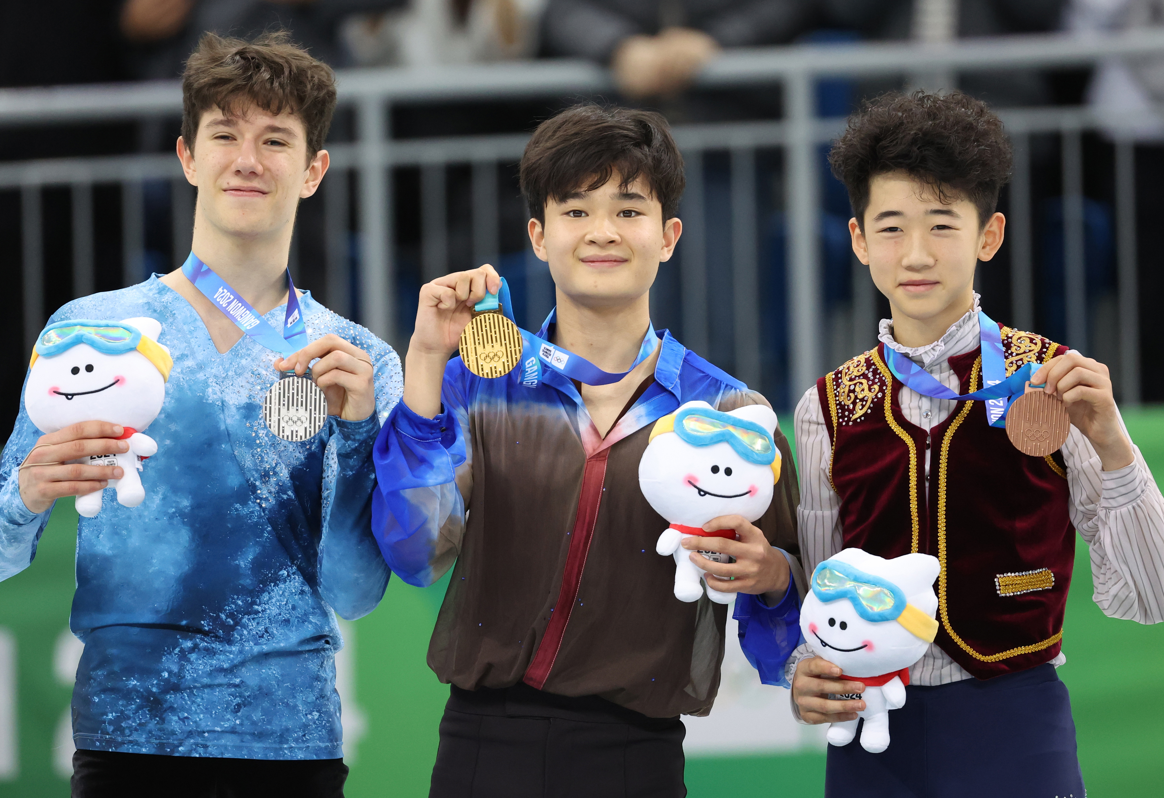 김현겸이 2024 강원 동계청소년올림픽 대회 피겨스케이팅 남자 싱글에서 한국 남자 선수로는 처음으로 금메달을 따낸 뒤 시상대에 올라 기뻐하고 있다. 왼쪽은 은메달을 딴 아담 하기라. 오른쪽은 리얀하오.  연합뉴스