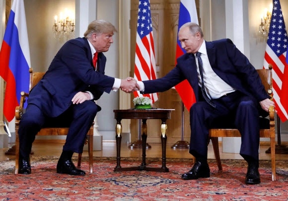 2018년 7월 16일(현지시간) 도널드 트럼프 미국 대통령과 블라디미르 푸틴 러시아 대통령이 핀란드 헬싱키의 대통령궁에서 첫 정상회담을 시작하기 전 서로를 바라보며 악수하고 있다. 로이터 연합뉴스