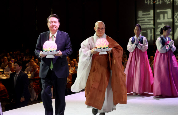 윤석열 대통령이 30일 서울 강남구 그랜드 인터컨티넨탈 서울 파르나스 호텔에서 열린 ‘새해맞이, 나라와 민족을 위한 불교 대축전’에서 한국불교종단협의회 회장 진우 스님과 함께 연등을 공양하고 있다.   2024.1.30  연합뉴스