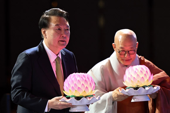 윤석열 대통령이 30일 서울 강남구 그랜드 인터컨티넨탈 서울 파르나스 호텔에서 열린 ‘새해맞이, 나라와 민족을 위한 불교 대축전’에서 한국불교종단협의회 회장 진우 스님과 함께 연등을 공양하고 있다.   2024.1.30   대통령실 제공